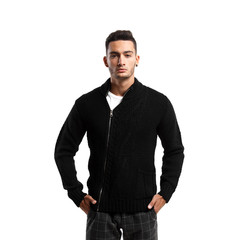 Fototapeta premium Young man dressed in black sweater with a zipper and gray plaid pants stands on the white background