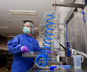 A young woman works in a hospital as a  medical hygiene worker. She is dressed  in special medical hygiene clothing and  carries out hygiene disinfecting and logistic tasks.