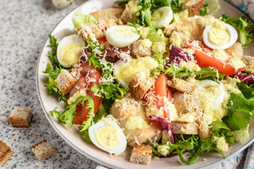 Fresh caesar salad with chicken breast, lettuce and tomatoes. Delicious spring salad