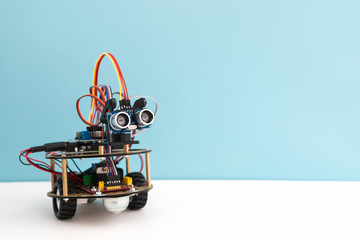 Hand made robot working on the arduino platform. White background. Free space for text. STEM education for children and teenagers, robotics and electronics. DIY. AI. STEAM. - obrazy, fototapety, plakaty
