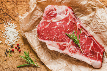 Raw angus meat steak on wooden board copy space.