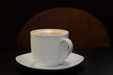Concept black coffee with foam and milk on a wooden table