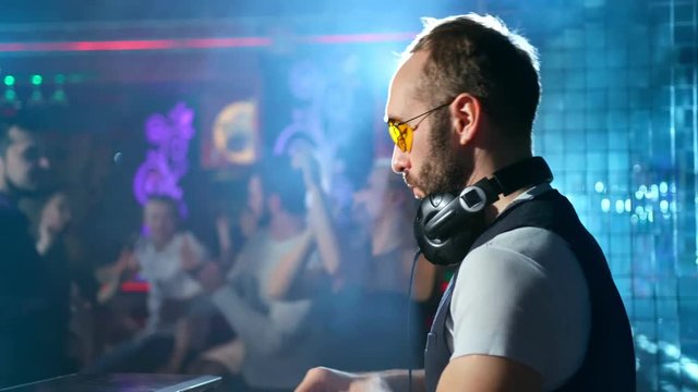 DJ is playing music and waving hands