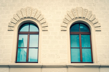 Two windows of a brick building with sky blue windows