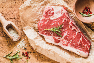 Raw angus meat steak on wooden board copy space.