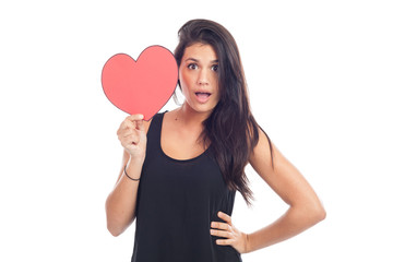 beautiful happy brunette woman holding and showing a big red heart