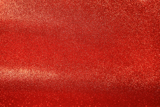 Close up of a red glittering blurry background with sparkling white spots