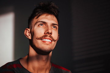 Young man smiling at window light