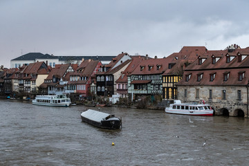 Blick auf die Regnitz, die Schiffe und Boote und Bamberger Architektur am Fluss.