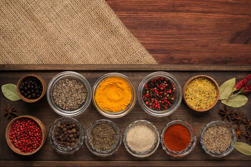 Spices and seasonings on the brown wooden board. Place for text