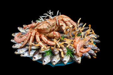 Big hairy boiled crab sits on a heap of dried salted fish on a gift bouquet on the black background