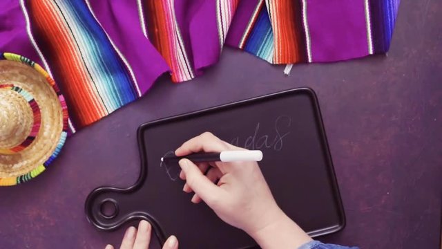 Flat lay. Writing Emapanadas sign on black chalk board.
