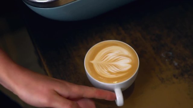 Barista makes coffee Latte with a heart shape in the foam for Valentines Day.