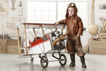 Boy in the image of a pilot playing with a plane