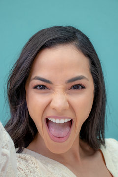 Elated, Excited Beautiful Young Woman Against A Solid Background