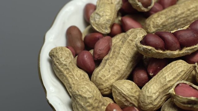 Peanuts. Mixed Peanuts in rotation. Snack closeup.  Peanuts in a bowl. Selective focus. grey background. Studio shot. Healthy food concept.