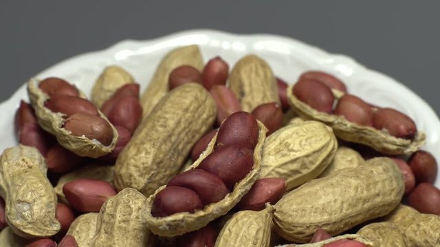 Peanuts. Mixed Peanuts in rotation. Snack closeup.  Peanuts in a bowl. Selective focus. grey background. Studio shot. Healthy food concept.