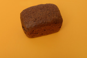 photo of handmade black bread on orange background