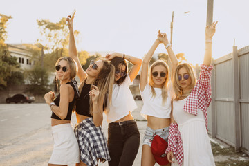 Five young women dance in a car park