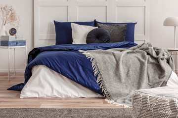 Grey and blue bedding and blanket on comfortable king size bed