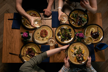 Group of people having dinner together while sitting at the table 