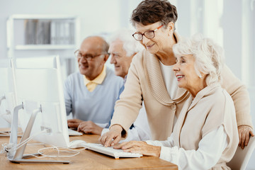 Senior women making project at computer class for elderly people