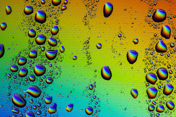 Drops of water on the glass, with the reflection of the rainbow.
