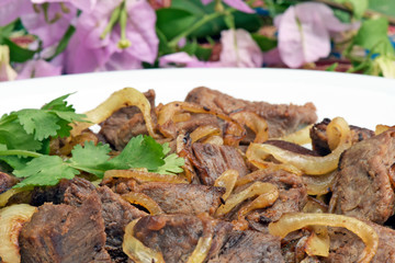 Portion of fried carne de sol in white plate