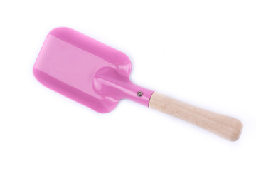 Metal/iron childrens shovel with a wooden handle on a white background isolated close-up. New garden tool. Children wooden/metal toy. Garden equipment. Pink color. Top view. Overturned.