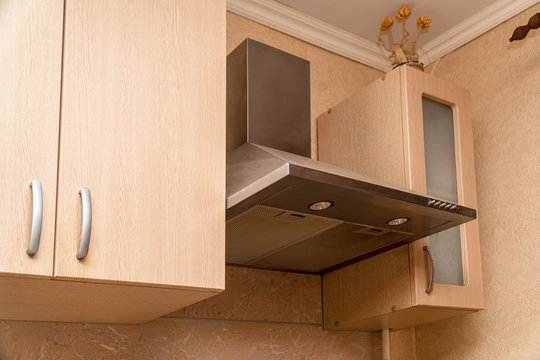 Hood Extractor Fan In The Kitchen Next To Hanging Cabinets