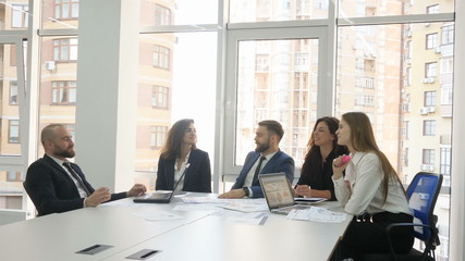 Office workers, employees of a large company, two young men and three young women discuss the firm's issues, the end of the meeting everyone talks to each other and smiles