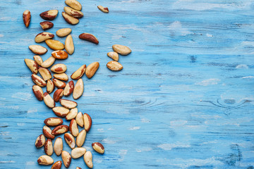 Brazil nuts on blue old background and space for text - obrazy, fototapety, plakaty
