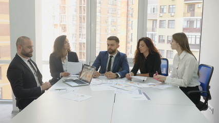 Business team discussing over laptop in meeting at office
