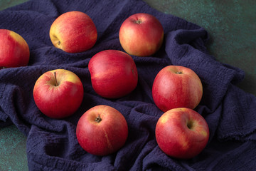 Fototapeta na wymiar Some ripe red apples on dark blue napkin