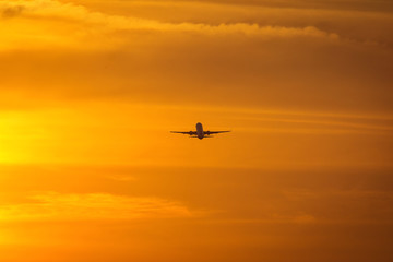 Small plane in the middle of the red clouds at sunset