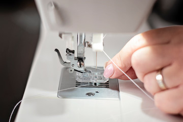 modern sewing machine close-up threading needle - image