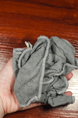 Grey rag for cleaning in the hand