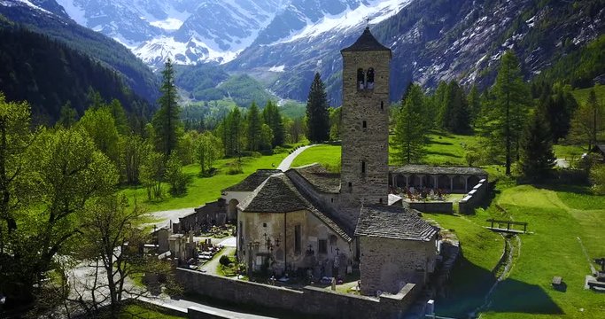 Aerial shot of an ancient medieval catholic church in the Italian alps