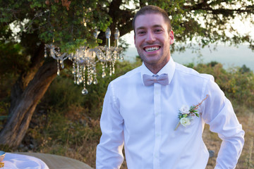 Attractive groom is looking forward to the appearance of the bride