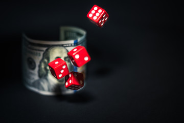 Thrown dice, on the background of a $ 100 bill with a portrait of Franklin.