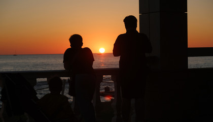 silhouette of man and woman walking in the sunset