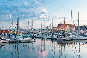 Paisaje en el que se ve un puerto deportivo con sus yates y sus barcos de vela atracados al...