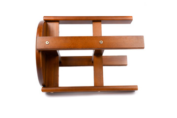 Wooden chair/stool isolated on white background. Dark brown wooden pine dining stool. Natural, solid wood bench. Side view. Chair lying on the ground. Isolated on the white background.