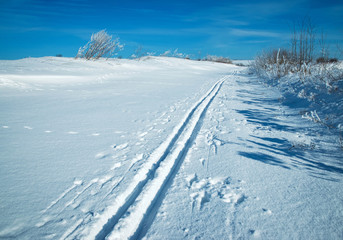 Fototapeta na wymiar snowy plain with a ski track