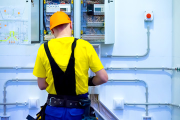 Electrician at work. A man collects electrical wiring. Construction works. Electrician mounts electrical panel. Electro shield. Engineering work on the construction of the house.