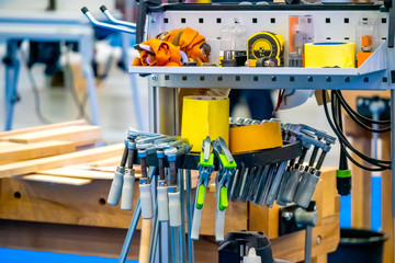 Tool for carpentry work. Rack with the tool. Joiner's clamp. Saw on a tree. Carpenter work.