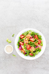 Healthy lunch vegetable salad with baked salmon fish, fresh green peas, lettuce and tomato. Top view