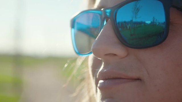 Young Beautiful girl with glasses  touching her hair in sunny weather