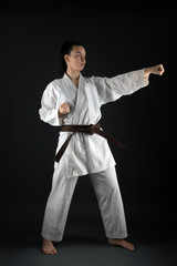 Young woman dressed in traditional kimono practicing her karate moves © muro