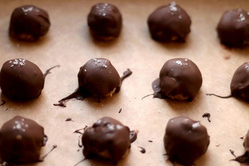 Homemade no-bake peanut butter and chocolate balls, sprinkled with pink salt. Selective focus. 